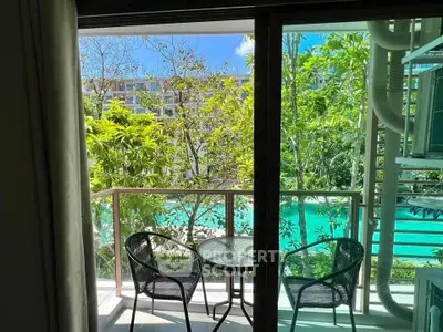 Charming balcony view overlooking lush greenery and inviting pool, perfect for relaxation.