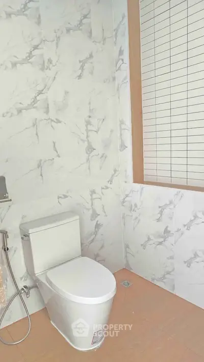 Modern bathroom with marble tiles and sleek toilet design