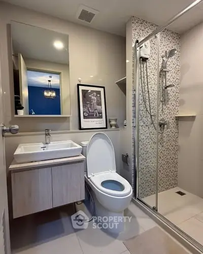 Modern bathroom with sleek shower and stylish vanity in contemporary apartment.