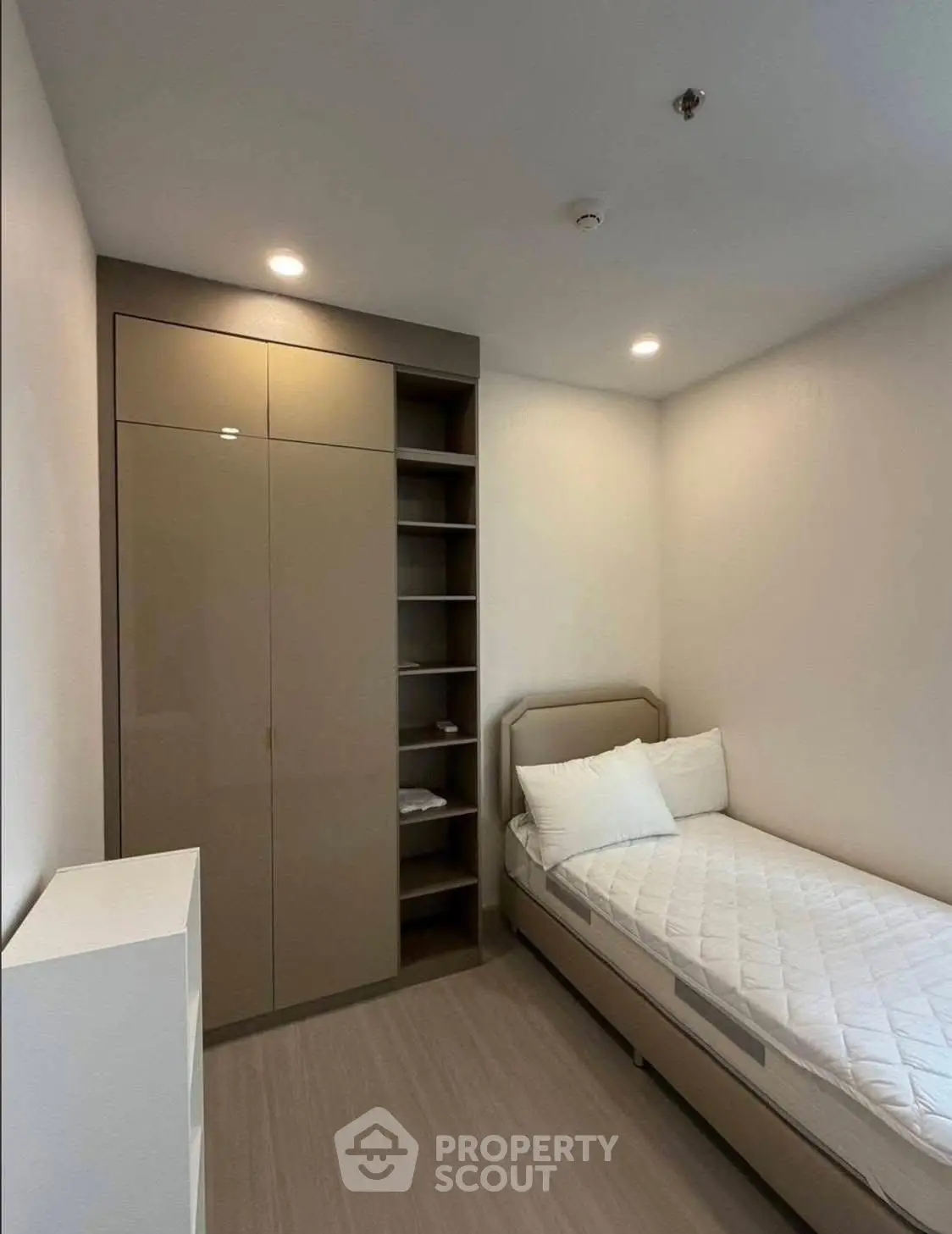 Modern minimalist bedroom with sleek built-in wardrobe and cozy single bed.