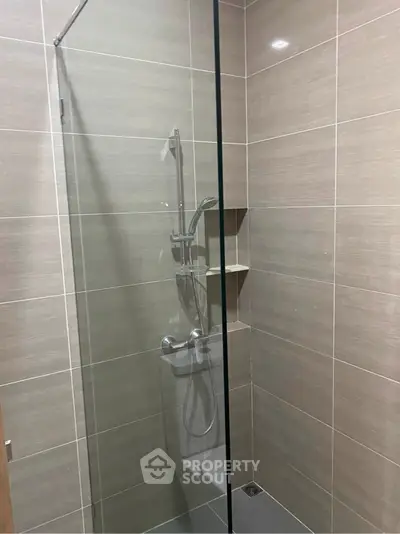Modern bathroom with sleek glass shower enclosure and tiled walls