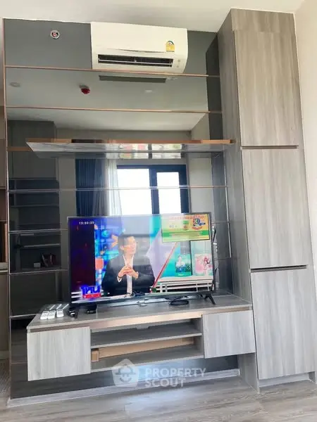 Modern living room with sleek entertainment unit and air conditioning