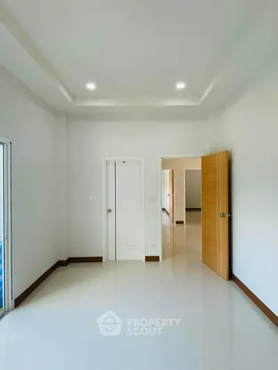 Spacious empty room with modern white interior and wooden doors