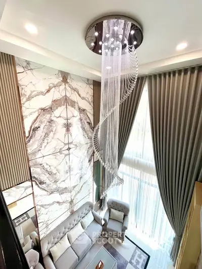 Luxurious living room with elegant chandelier and marble accent wall