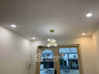 Modern interior with stylish lighting and glass doors leading to a balcony.