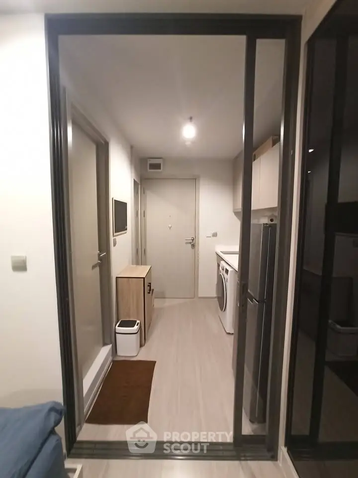 Modern apartment hallway with washing machine and sleek storage solutions