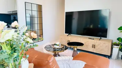 Stylish living room with modern decor, large TV, and elegant furniture, perfect for relaxation and entertainment.