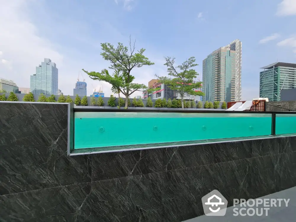 Modern rooftop pool with city skyline view and lush greenery