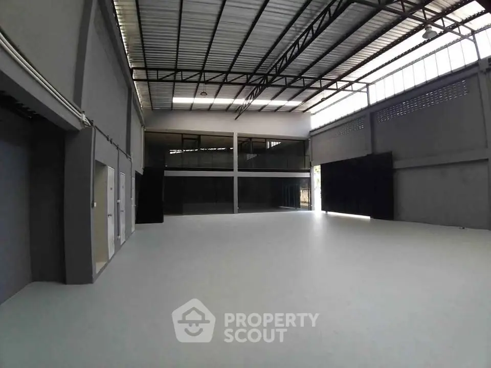 Spacious industrial warehouse with high ceilings and ample natural light.