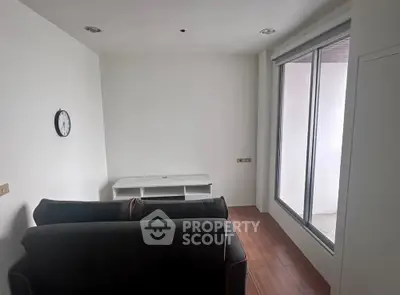Minimalist living room with sleek sofa and large window for natural light