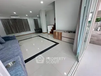 Spacious modern living room with sleek tile flooring and large windows for natural light.