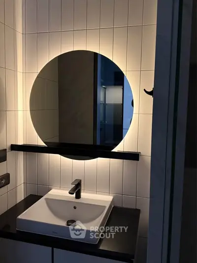 Modern bathroom with stylish round mirror and sleek sink design