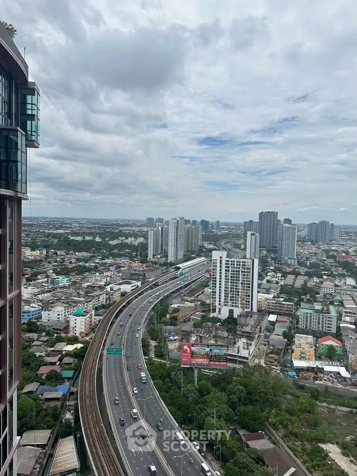 Stunning cityscape view from high-rise building showcasing urban skyline and highway.