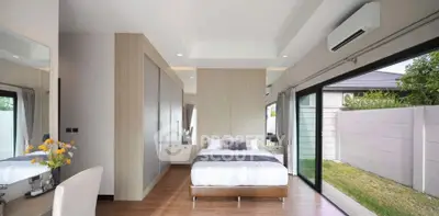 Modern bedroom with large windows and garden view, featuring sleek design and ample natural light.