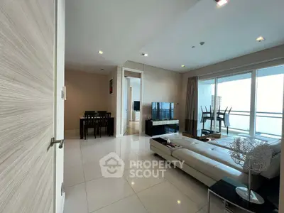 Spacious modern living room with sleek furniture and large balcony view.