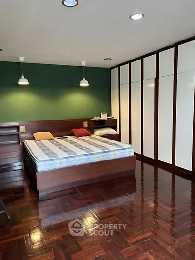 Spacious bedroom with wooden flooring and built-in wardrobe