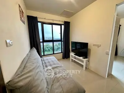 Cozy living room with a large window offering a scenic view, featuring a comfortable sofa and modern TV setup.