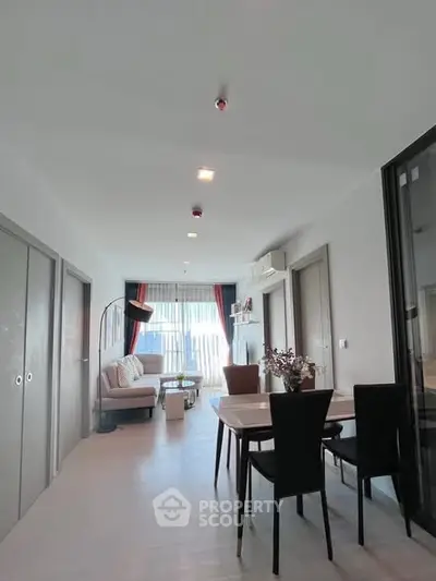 Spacious modern living room with dining area and large windows in a stylish apartment.