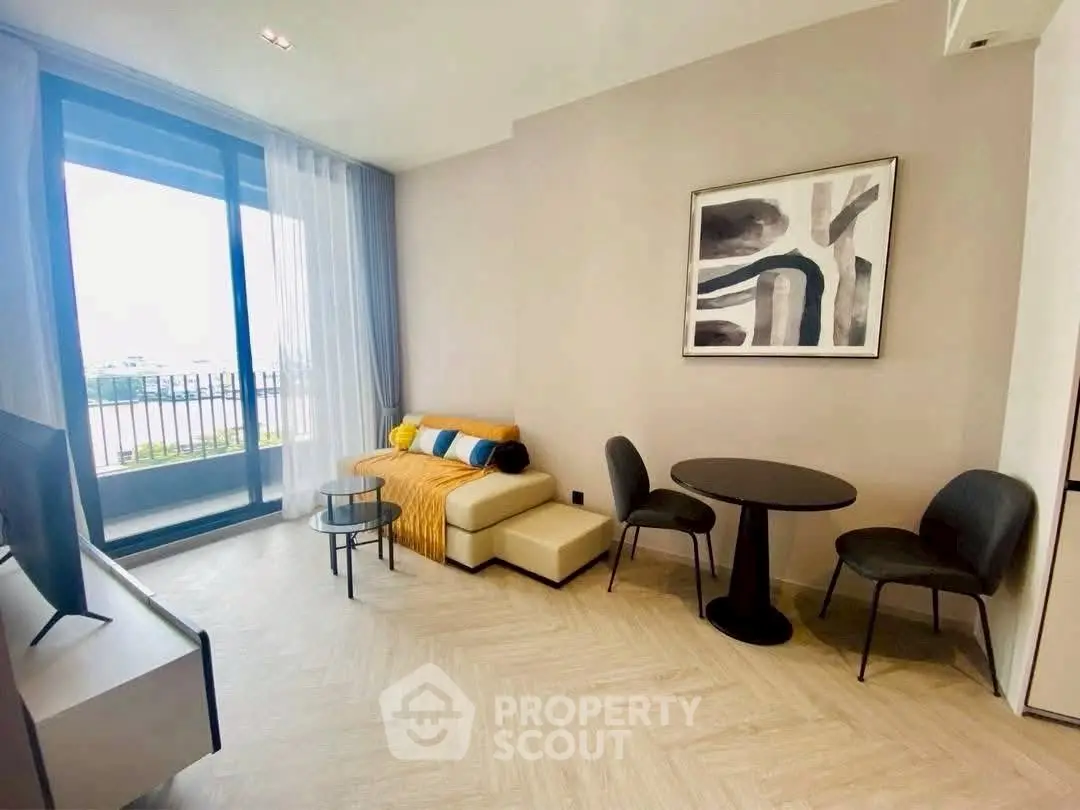 Modern living room with stylish decor and large window offering natural light and balcony view.