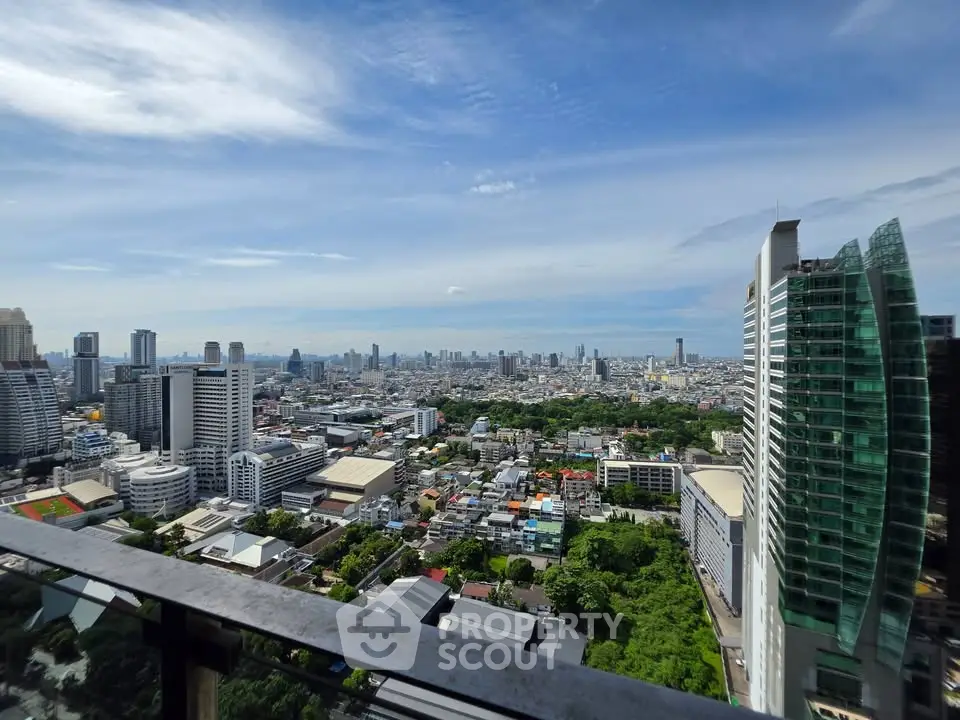Stunning cityscape view from high-rise balcony with modern skyline and lush greenery.