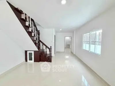 Spacious modern living room with elegant staircase and large windows