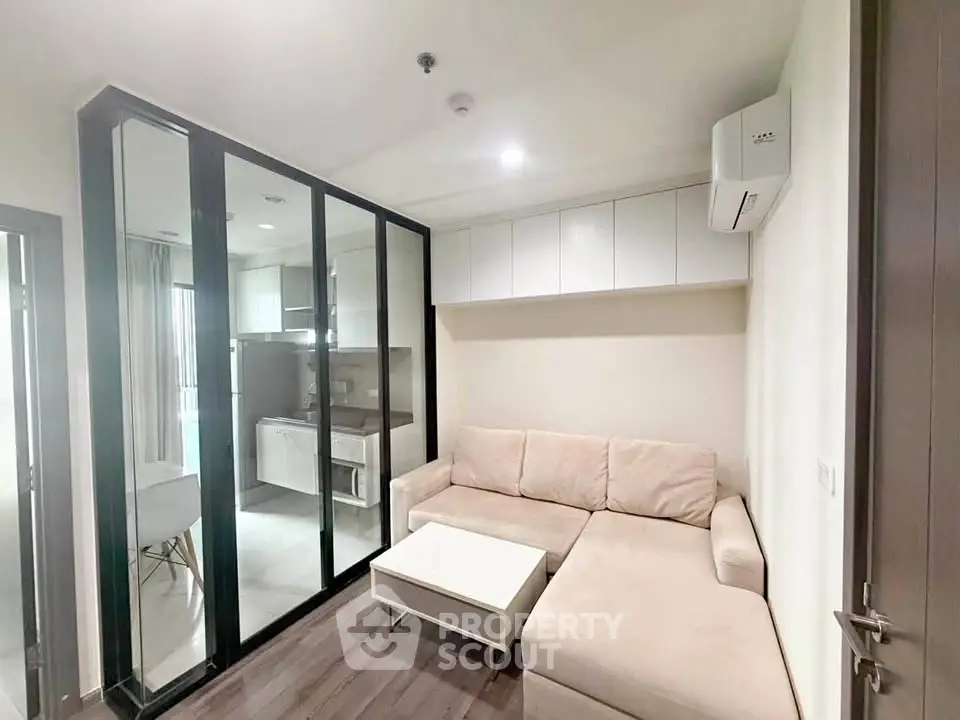 Modern living room with glass partition and cozy beige sofa in a stylish apartment.