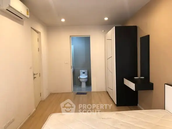 Modern bedroom with ensuite bathroom and sleek furniture design.