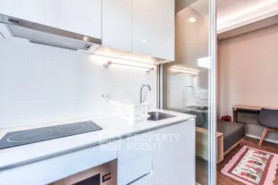 Modern compact kitchen with sleek white cabinets and built-in appliances