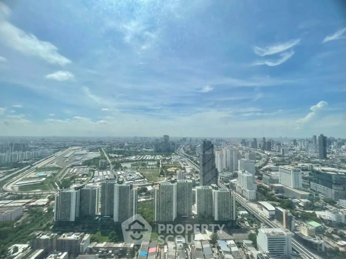Stunning panoramic cityscape view from a high-rise building, showcasing urban skyline and blue skies.
