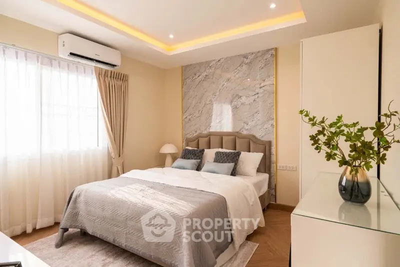 Luxurious bedroom with elegant decor and natural light, featuring a plush bed and stylish accents.