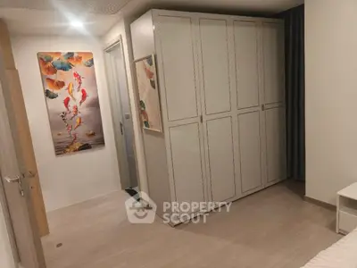 Modern bedroom with sleek wardrobe and artistic wall decor