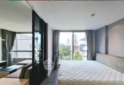 Modern bedroom with large windows offering city views in a stylish apartment.