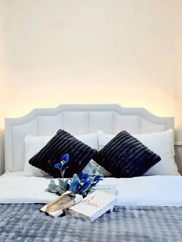 Elegant bedroom with plush pillows and stylish decor, perfect for relaxation and comfort.