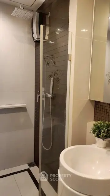 Modern bathroom with sleek shower and stylish sink in contemporary apartment.