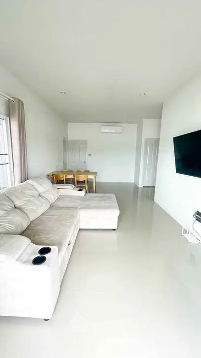 Spacious modern living room with sleek furniture and wall-mounted TV