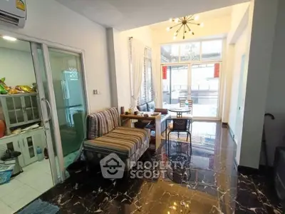 Stylish living room with modern decor and marble flooring, featuring a cozy dining area and ample natural light.