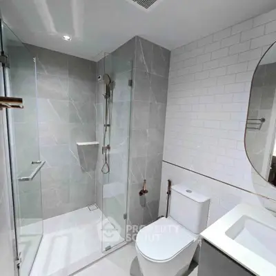 Modern bathroom with glass shower, sleek tiles, and contemporary fixtures.
