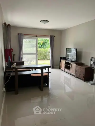 Spacious living room with modern furniture and garden view, perfect for relaxation and entertainment.