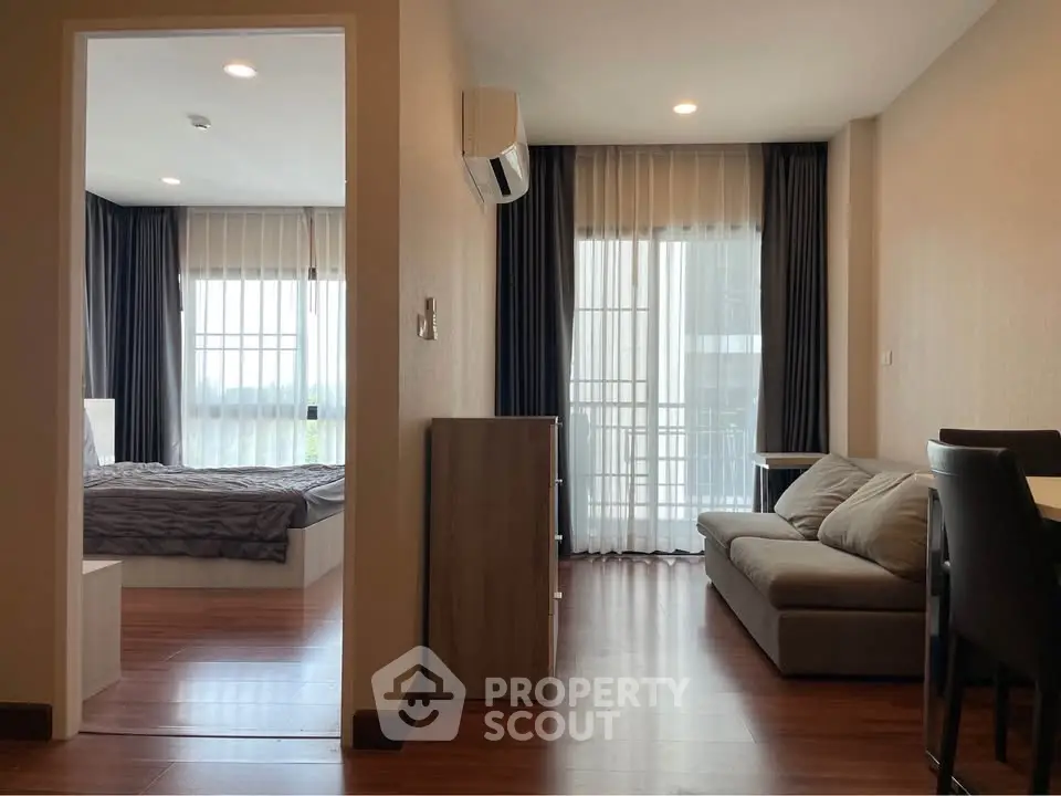 Modern apartment interior with cozy living room and bedroom, featuring large windows and elegant curtains.