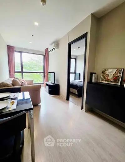 Modern apartment interior with cozy living room and bedroom view, featuring large windows and stylish decor.
