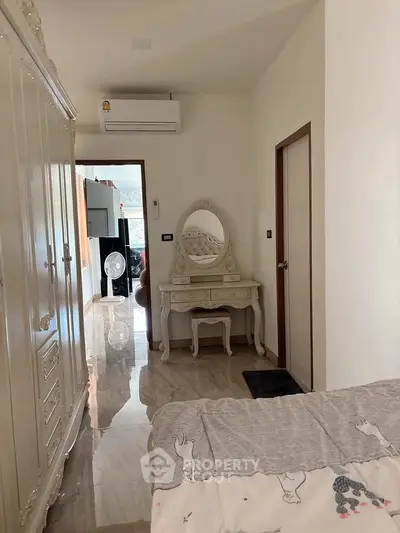 Charming bedroom with elegant vanity and classic wardrobe, perfect for cozy living.