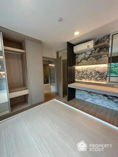 Modern bedroom with built-in wardrobe and stylish marble accent wall