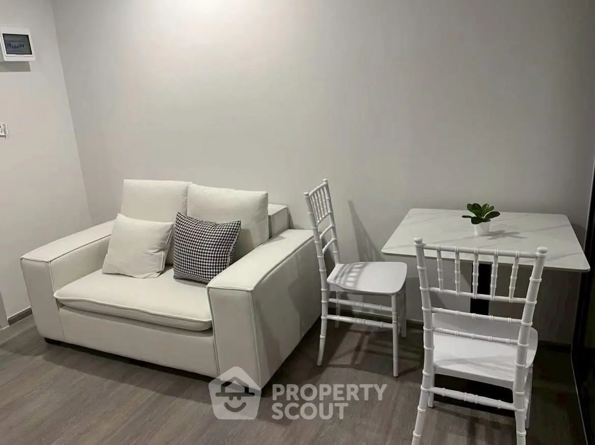 Cozy modern living room with white sofa and dining set, perfect for small spaces.