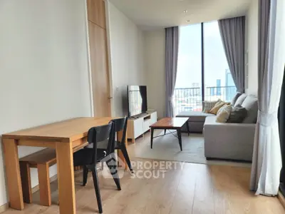 Modern living room with city view, featuring sleek furniture and large windows for natural light.