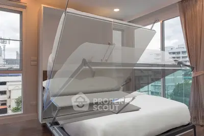 Modern bedroom with innovative foldable bed and large windows offering city views.