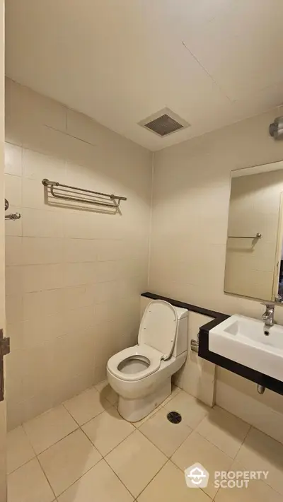 Modern bathroom with sleek fixtures and neutral tiles in a contemporary home.