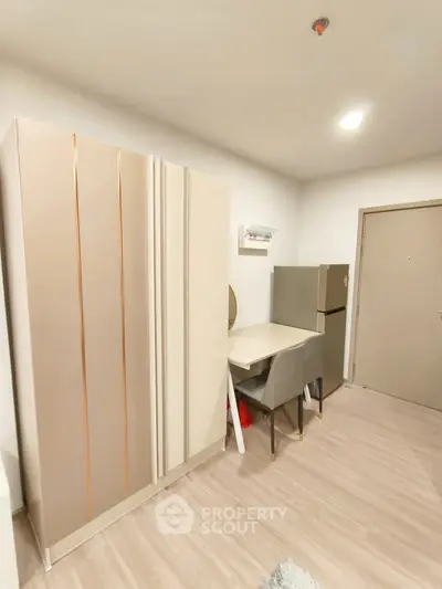 Modern apartment interior with sleek furniture and compact kitchen area.