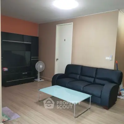 Cozy living room with modern sofa and glass coffee table, perfect for relaxation.