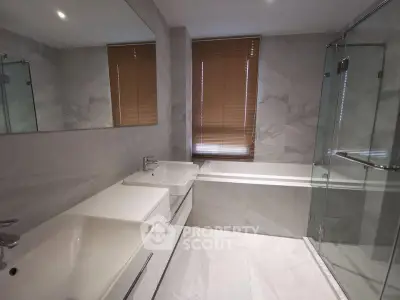 Modern bathroom with dual sinks, bathtub, and glass shower enclosure.