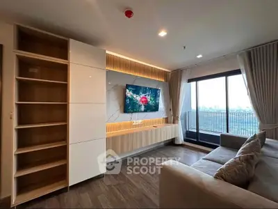 Modern living room with built-in shelves, large TV, and city view balcony.